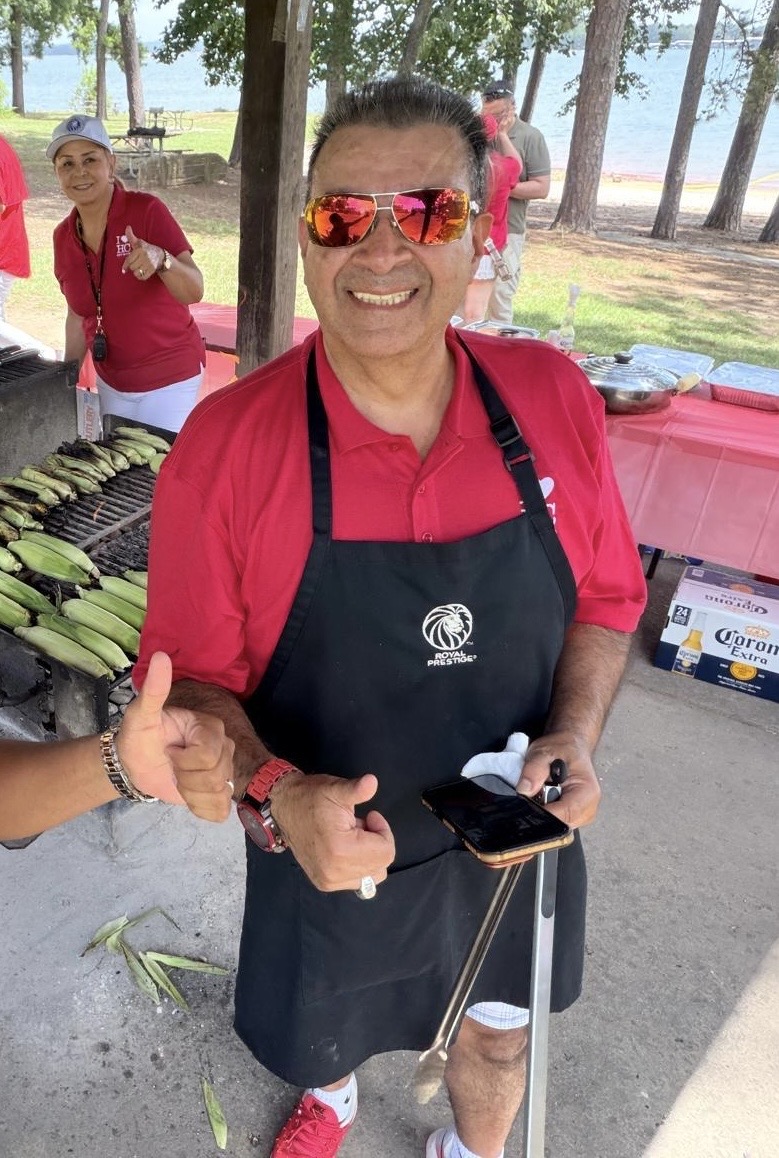 Carlos Eduardo Aguirre cocinando con su equipo en una parrillada de Royal Prestige